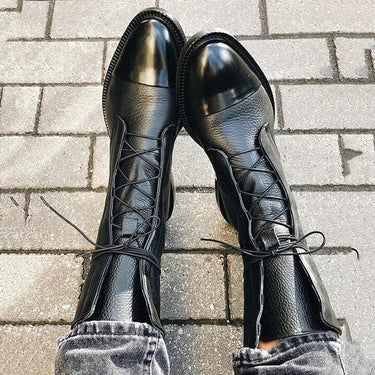 Front view of lace-up leather ankle boots on a plain background