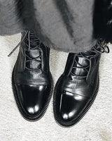Close-up of the lace-up closure detail on leather ankle boots