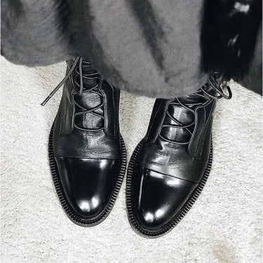 Close-up of the lace-up closure detail on leather ankle boots
