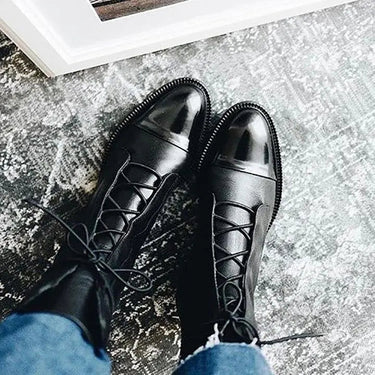 Overhead view of lace-up leather ankle boots on flat surface