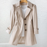 Back view of the longline trench coat showing structured shoulders and straight-cut hem