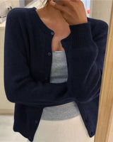 Front view of a button-front knit cardigan with round neckline and ribbed cuffs