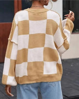 Side view of the checked jumper highlighting the straight hem and sleeve length