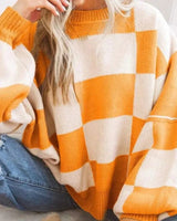 Woman wearing the checked jumper in orange paired with casual trousers