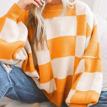Woman wearing the checked jumper in orange paired with casual trousers
