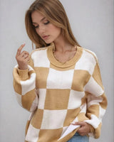 Woman wearing a checked knitted jumper in dark pink with long sleeves and round neckline