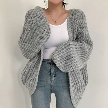 Styled shot of chunky knit cardigan layered over a simple dress
