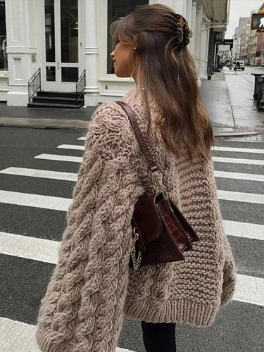 Front view of women's cable-knit cardigan in a relaxed hip-length silhouette