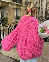 Close-up of bold cable-knit texture on women's open-front cardigan