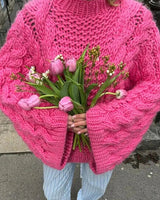 Women's chunky knit cardigan styled with jeans and ankle boots