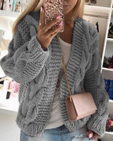 Model wearing open-front cable knit cardigan over a simple top