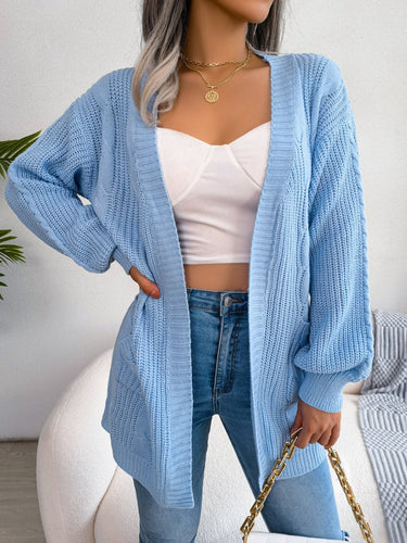 Back view of oversized cable knit cardigan showing dropped shoulder and length