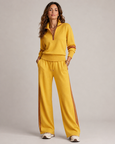 Side view showing wide-leg trousers with side piping and pocket detail