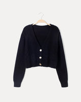 Close-up of cable knit chest panels and horn button fastening