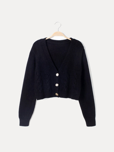 Close-up of cable knit chest panels and horn button fastening