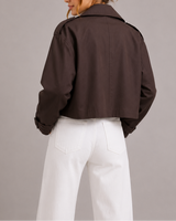Side view showing the cropped hemline and tailored silhouette of the trench coat