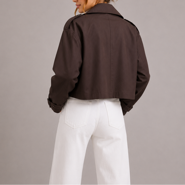 Side view showing the cropped hemline and tailored silhouette of the trench coat