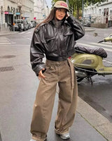 Model wearing the cropped jacket over high-waisted trousers