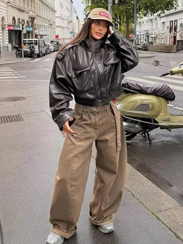 Model wearing the cropped jacket over high-waisted trousers