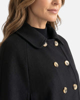 Side view showing the flared drape and side slit of the cape coat