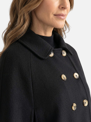 Side view showing the flared drape and side slit of the cape coat