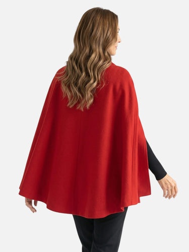 Three-quarter view of the cape coat layered over a knit, showing the overall shape