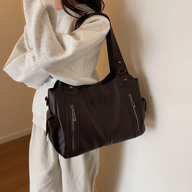 Side profile of the bag highlighting the depth and layered zip compartments