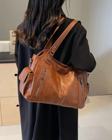 Model carrying the bag on one shoulder in an upright position