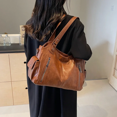 Model carrying the bag on one shoulder in an upright position