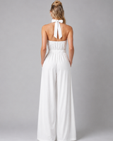 Side view showing the flowing wide-leg silhouette and clean drape of the jumpsuit