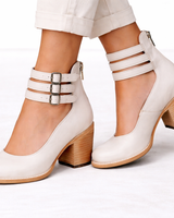Women's heeled ankle boots styled with tailored trousers, full-length shot