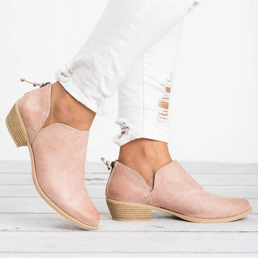 Ankle boots styled with tailored trousers, showing full boot profile