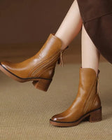 Heeled ankle boot with leather-look upper and side zip tassel pull, front view