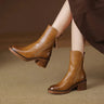 Heeled ankle boot with leather-look upper and side zip tassel pull, front view