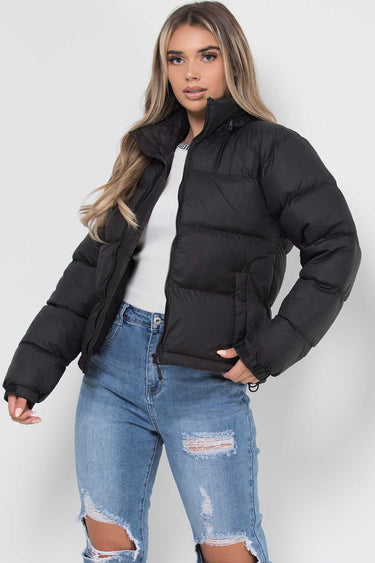 Front view of a longline quilted hooded puffer jacket with zip fastening
