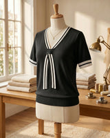 Close-up of the V-neckline and tie detail on the knit top