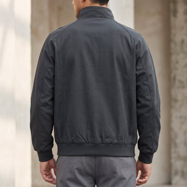Side view showing ribbed cuffs and hem of a faux leather bomber jacket