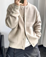 Side view of men's knit cardigan showing patch pocket and ribbed cuff detail