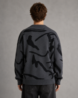 Men's graphic knit jumper shown with drop shoulder silhouette, side view
