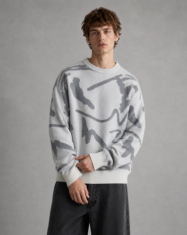 Men's abstract graphic jumper layered over a plain crew-neck tee