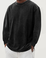 Close-up of crew neckline and ribbed cuffs on men's knit jumper