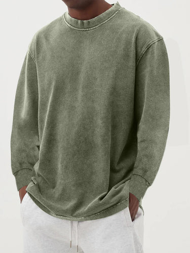 Men's chunky knit jumper styled with straight-leg trousers, three-quarter view