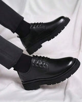 Men's chunky derby boots styled on foot, three-quarter angle view
