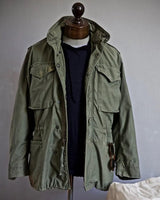 Front view of men's hooded field jacket with snap-button chest pockets and cargo pockets
