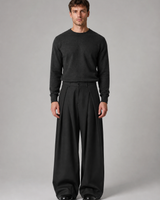 Side view showing the wide leg cut and drape of the trousers