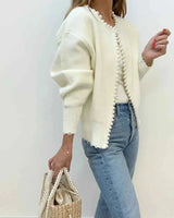 Close-up of pearl-style beading detail along the cardigan hem and cuffs