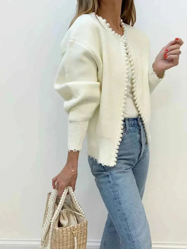 Close-up of pearl-style beading detail along the cardigan hem and cuffs