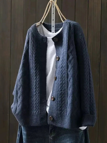 Detail shot of ribbed cuffs and button closure on cable knit cardigan