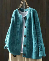 Styled shot of cable knit cardigan worn open over a casual outfit