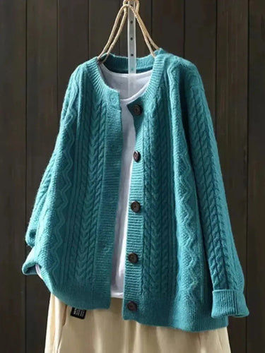 Styled shot of cable knit cardigan worn open over a casual outfit